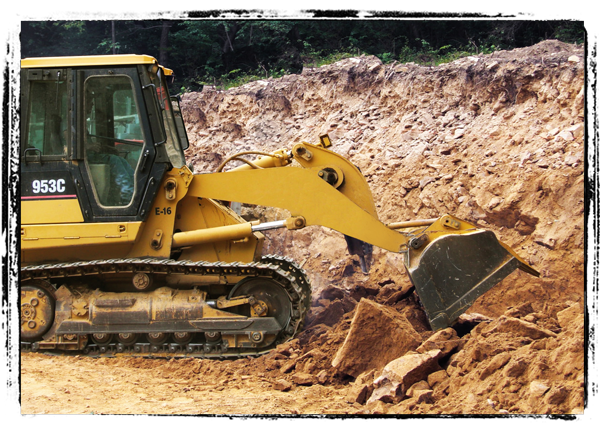 Image: Bulldozer removing dirt for residential construction.