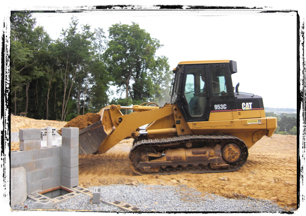 Image: Bulldozer moving dirt to install septic tank.